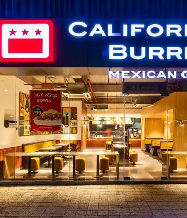 Brightly lit dining area at a California Burrito Mexican Kitchen, a vibrant restaurant located in Good Earth Business Bay I, offering a cozy spot for office workers and visitors.