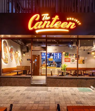 Contemporary dining space with vibrant murals and modern furniture at The Canteen Project, a popular eating joint within Good Earth Business Bay I, Gurugram.