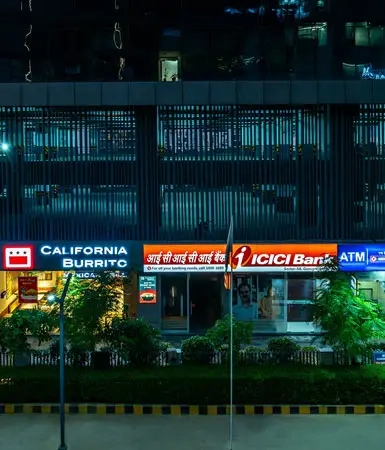 Evening shot of California Burrito and ICICI Bank ATM at Good Earth Business Bay I, Gurugram, highlighting the commercial spaces and accessible services.