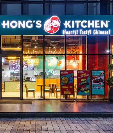 Exterior of Hong's Kitchen, a vibrant Chinese restaurant at Good Earth Business Bay II, Gurugram, offering hearty and tasty meals in a corporate setting.