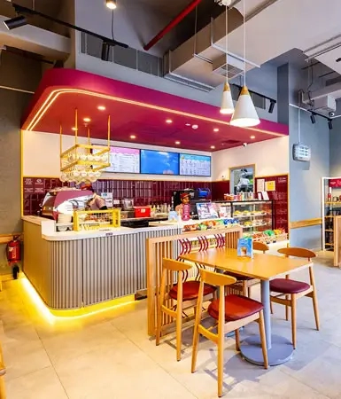 Interior of a café at Good Earth Business Bay II, Gurugram, featuring modern furniture and a welcoming ambiance for employees and clients to enjoy refreshments.