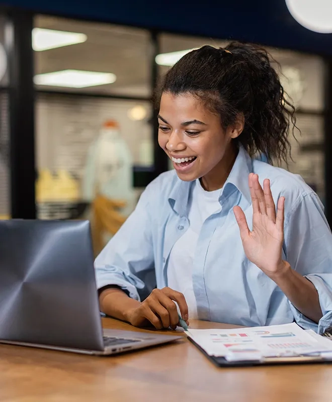 Employee smiling and waving during a video call, reflecting the family values at the heart of our real estate business.