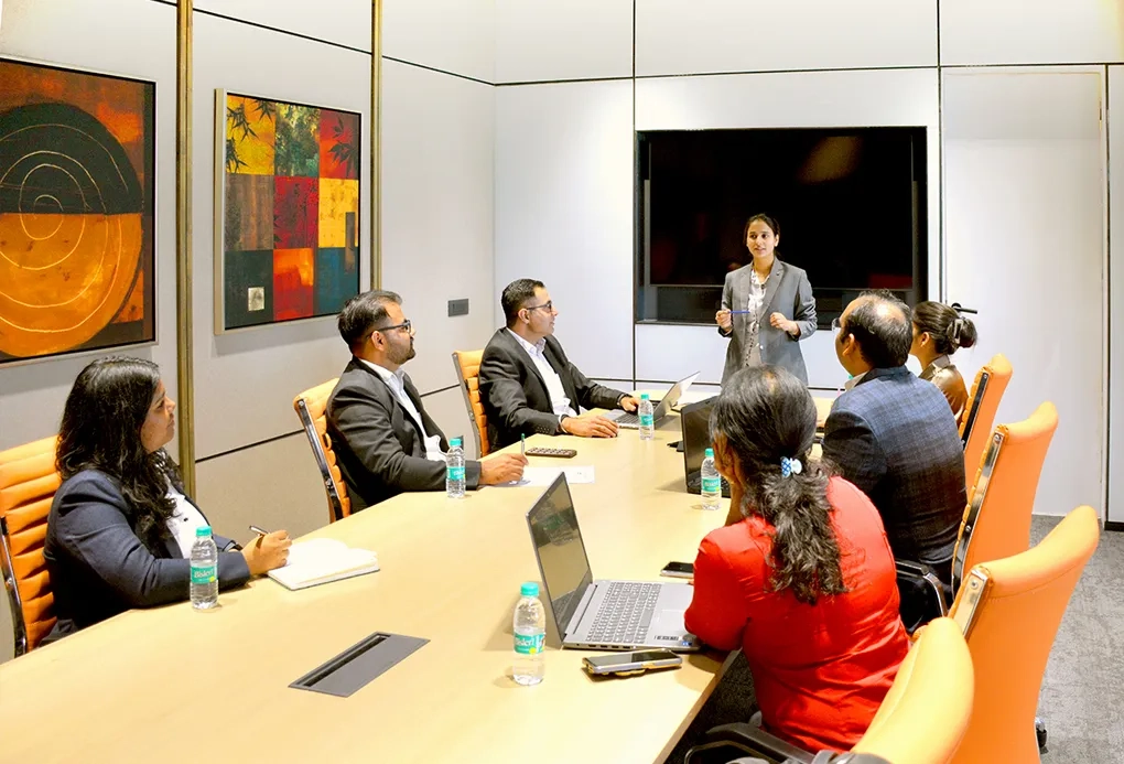 A meeting in progress with executives discussing commercial real estate strategies in a modern conference room at Good Earth Infra.