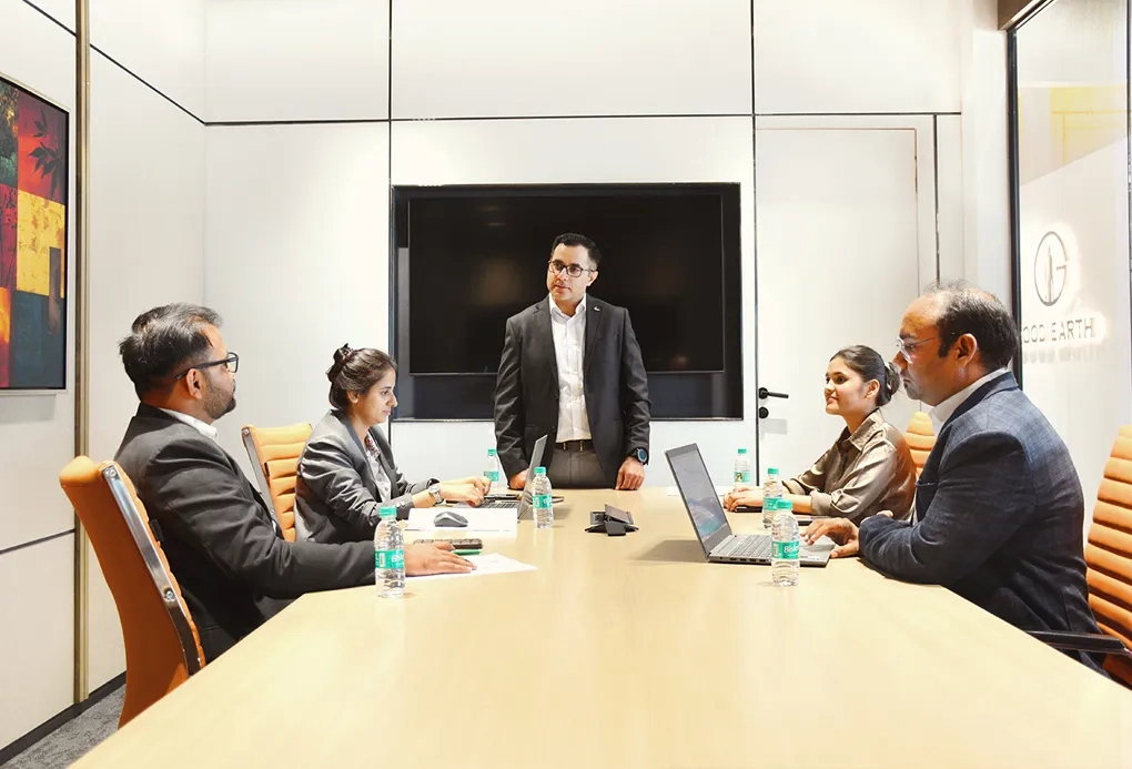 Leasing experts engaging in a discussion about office space leasing opportunities in Good Earth Infra's conference room.