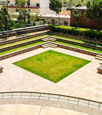 A serene green area with tiered seating, designed for relaxation and events at Good Earth Trade Tower, providing a pleasant environment for corporate events.