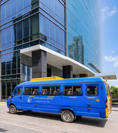 Shuttle bus parked outside Good Earth Trade Tower, ensuring smooth access to the Metro for office employees.