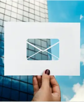 Holding an envelope in front of a commercial building, symbolizing trust and transparency in our real estate business in a fast-changing market like India.